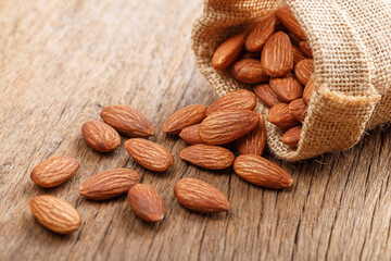 Almond snack fruit in a brown sack on a wooden floor