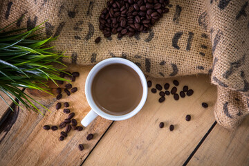 Coffee with beans on wooden table, with a notebook and laptop-organizeing day