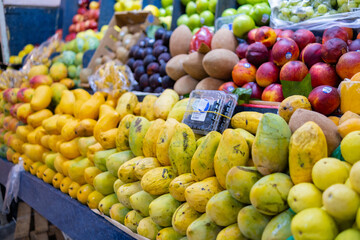 Colorful fruit stand with mangoes, peaches, mamey, green apples, and more