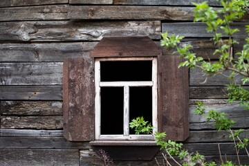 black empty window of old abandoned wooden house