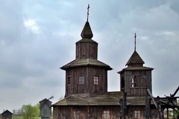 old abandoned wooden church with crosses on background of gloomy sky