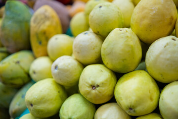 Close-up of colorful fruit stand with guavas and mangoes