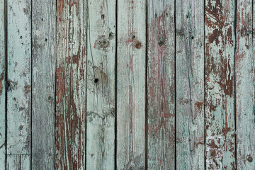 Wooden aged paint background. Dark turquoise paint has cracked from time to time on solid wood planks that are stacked vertically.