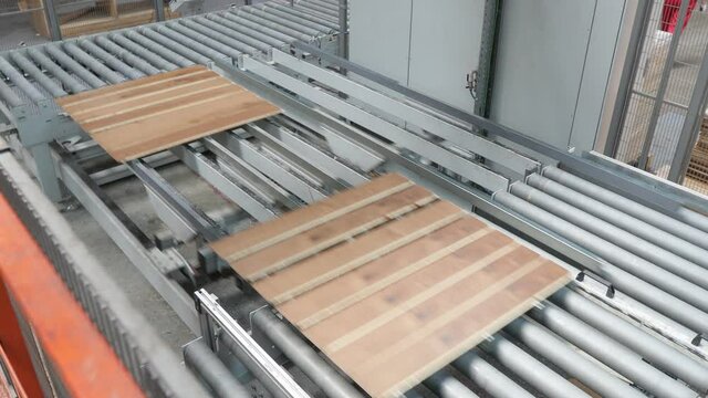 Carpentry factory. Production line of parquet board. Modern industrial factory for laminated flooring.