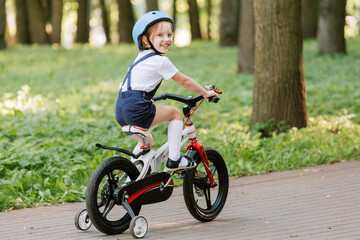Cheerful smiling girl in helmet on bicycle.