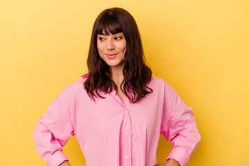 Young caucasian woman isolated on yellow background dreaming of achieving goals and purposes