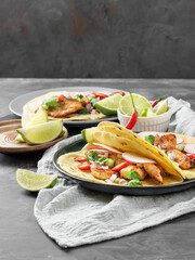 Tacos with chicken, vegetables and lime on the table.