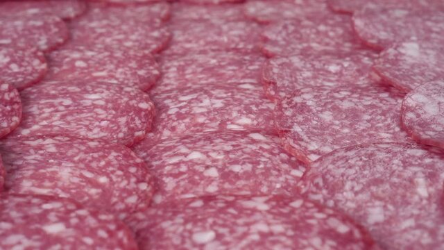Freshly sliced meat gourmet salami sausage, stacked in rows. Macro. Dolly Shot