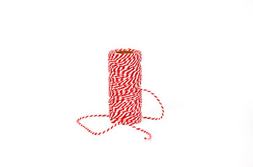 Red and white thread on white background. Roll red rope.