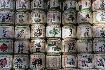 Traditional Sake barrels at the entrance to Meiji shrine in Tokyo.. The writings in Japanese inform of the content of barrels and religious verses