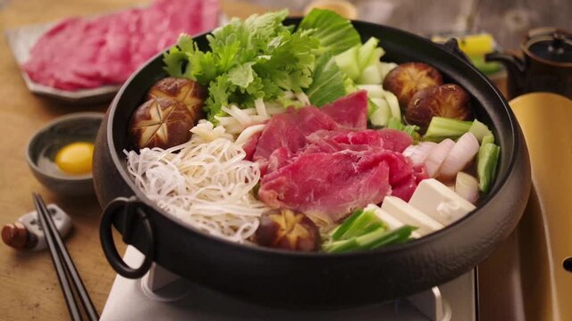 Modern style traditional Japanese sukiyaki stew served in a design cast iron pot