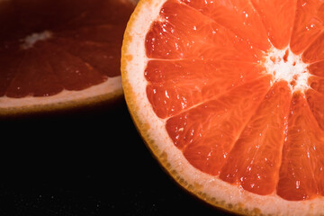 Pink grapefruit round slice on black. Grapefruit pink. It was flat. Top view.