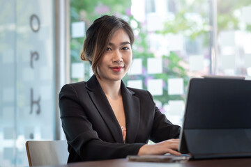 Beautiful businesswoman sitting at the office. Looking at the camera