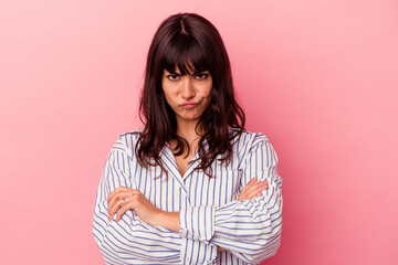 Young caucasian woman isolated on pink background blows cheeks, has tired expression. Facial expression concept.