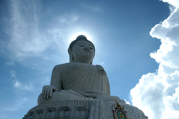 Fototapeta premium Big Buddha statue and sun above his head, creating a halo