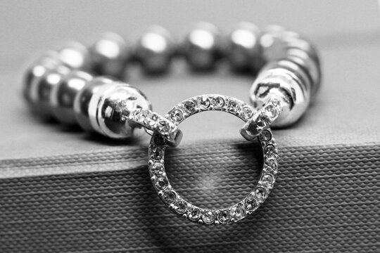 Bracelet made of beads and diamonds macro, black and white image