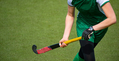 Hockey player woman with ball in attack playing field hockey game.