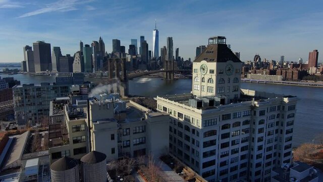 Excellent aerial of Dumbo Brooklyn apartments with Brooklyn Bridge, East River and New York City skyline in distance.