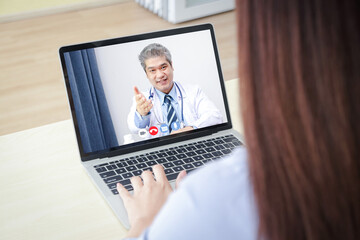Fototapeta na wymiar Online doctor concept Monitor patient health through a laptop connected to communication via online technology. The doctor can examine the patient via video call. Hospital services