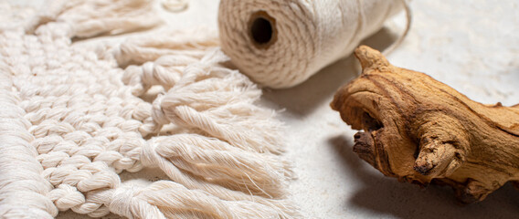 Macrame accessories on cream color background. Creative hobby concept. Top view