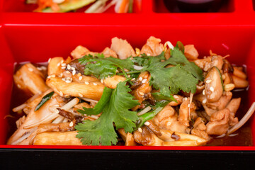 pieces of fried meat with mushrooms, in sauce, served with greens and sesame