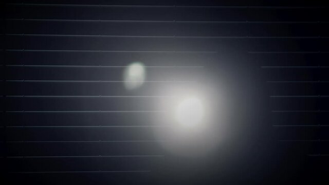 Hooded stranger in a dark room with flashlight