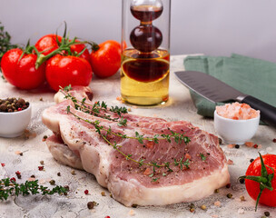 Raw meat for steak with ingredients for cooking on a light background. Bone steak.