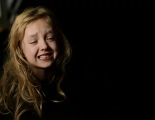Foto auf Acrylglas Horizontal, Close up portret of  crying young girl, on black background. © Lidia