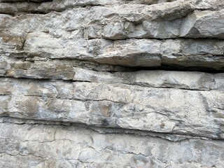Close up of uneven mountain with cracks. Texture of huge mighty rock.