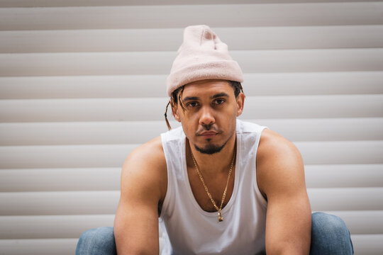 Fashion portrait of a handsome male with white vest and wooly hat