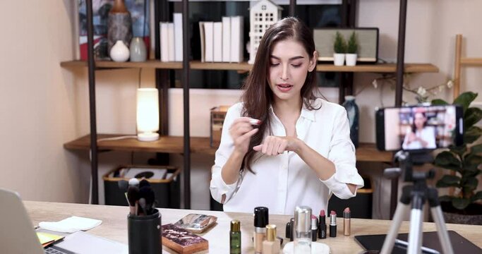 Video beauty blogger, The cheerful beautiful female blogger is introducing makeup products while recording videos and giving advice on her beauty blog.