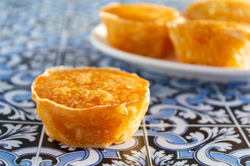 Traditional portuguese sweet bean pastry called Pastel de Feijao on portuguese tiles background