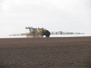 Traktor beim Spritzen im Frühjahr auf dem Acker