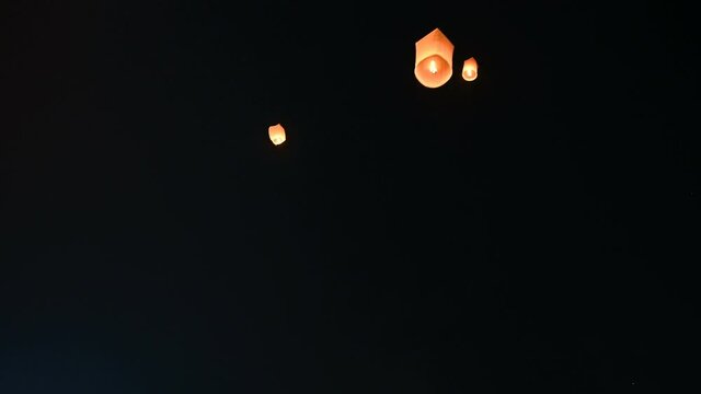 Floating lanterns in the night sky. Launching Sky Lantern. Yee Peng Festival, Loy Krathong celebration.