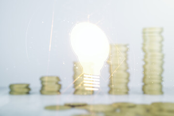 Abstract virtual light bulb hologram on growing coins stacks background, idea concept. Multiexposure