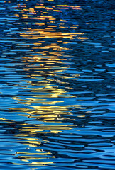 Evening river water texture with light reflection from a lantern.
