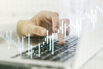 Abstract creative financial graph with hand typing on laptop on background, financial and trading concept. Multiexposure