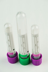 vacuum tubes for collection and blood samples on white background..Transparent with purple and green lid. Label to identify the data. Selective focus.