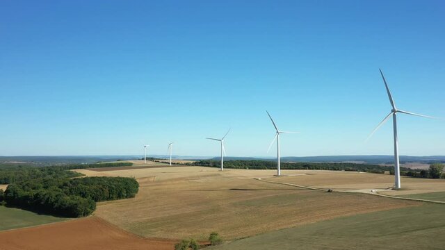 Les &eacute;oliennes dominent la campagne nivernaise, ses champs de bl&eacute; apr&egrave;s la moisson et les for&ecirc;ts verdoyantes &agrave; Oisy, vers Clamecy, dans la Ni&egrave;vre, en Bourgogne, en France, en &eacute;t&eacute; et en drone