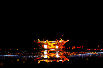 Drops of water colliding with powdered dye to create a multi coloured abstract droplet collision
