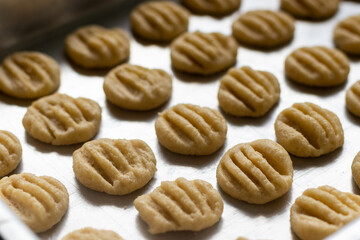 Biscoito caseiro amanteigado cru, numa fôrma de alumínio, antes de ser assado.