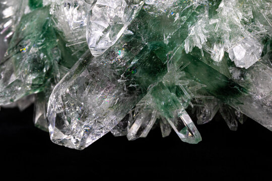 Chlorinated quartz crystals from the Himalayas. The larger, main crystals colored green and white are surrounded by hundreds of tiny, needle-like crystals. Shown with black background.
