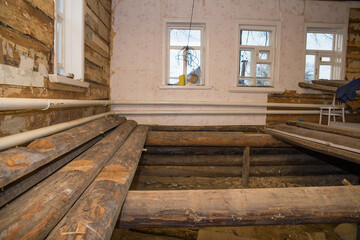 old village house with disassembled floor. Renovation in a village house. Selective focus on logs...