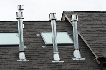 Detailed view of a newly installed steam ventilation pipe within home exhaust pipes on the hous