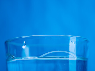 glass of water on a blue background. close-up