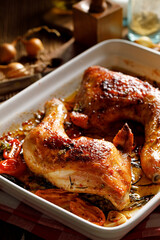 Baked chicken quarters in a baking dish, close up view