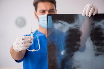 Young male doctor radiologist working in the clinic during pande