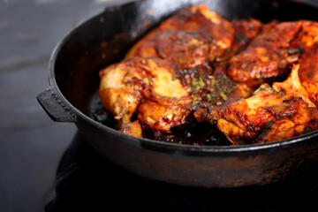 Appetizing grilled chicken in a cast iron pan.