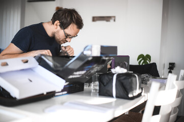 portrait of a handsome nerd man is servicing Computer motherboard and cooler.