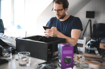 portrait of a handsome nerd man is servicing Computer motherboard and cooler.